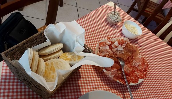 Tigelle e affettati sulla tovaglia a quadretti